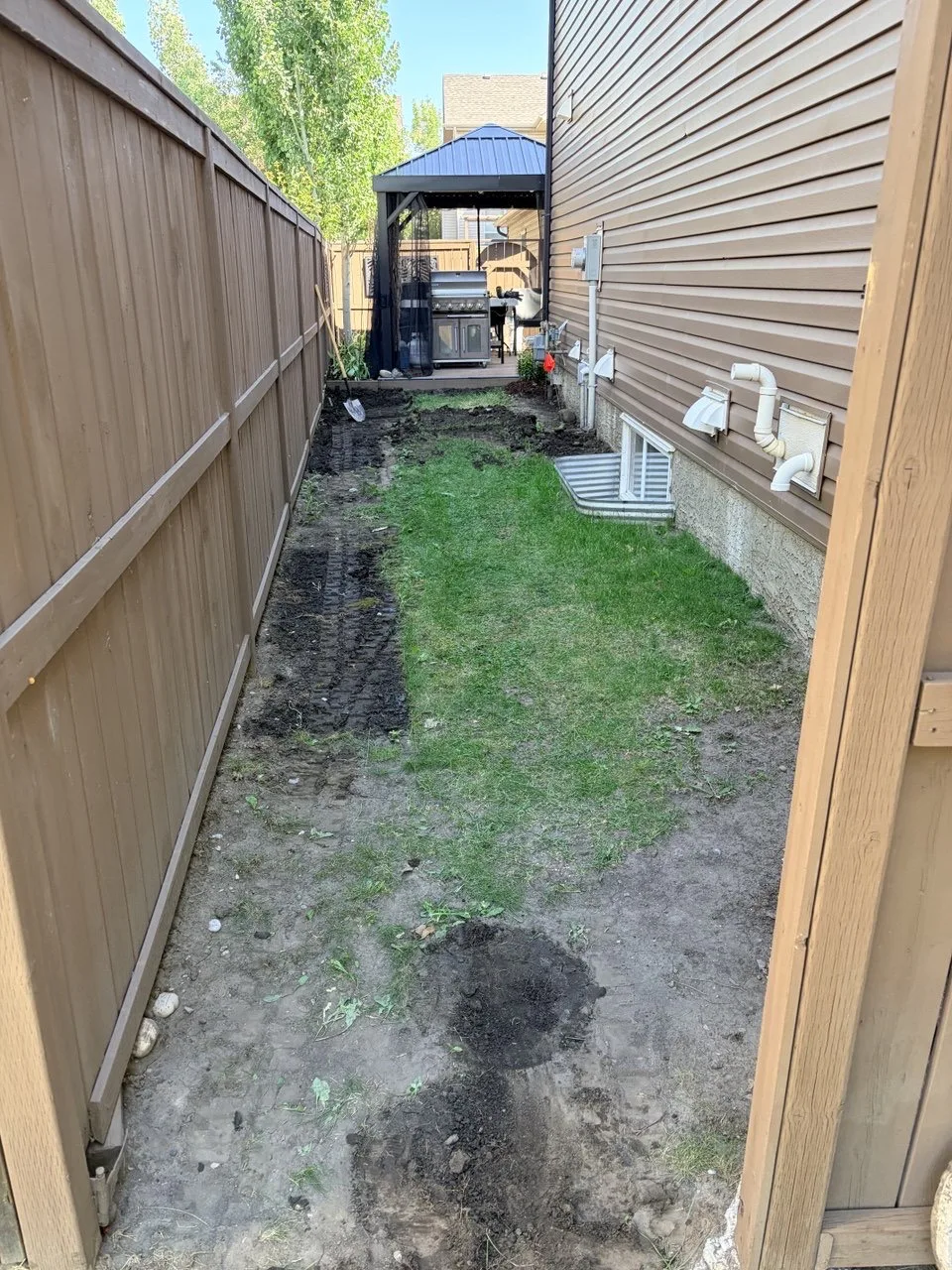 Calgary side yard before grass and soil removal for artificial turf base preparation