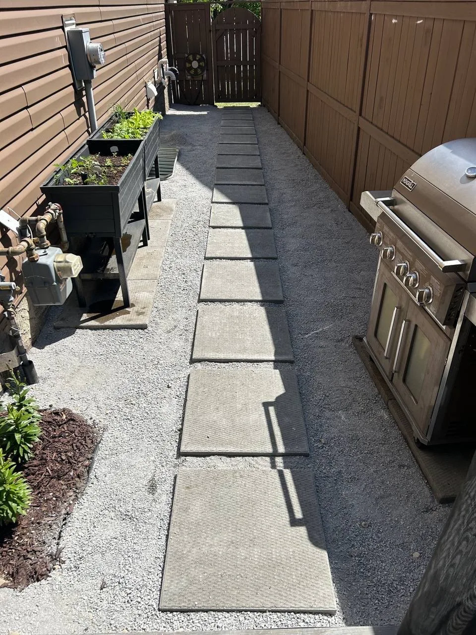 Compacted artificial turf base with walkway viewed across a Calgary side yard