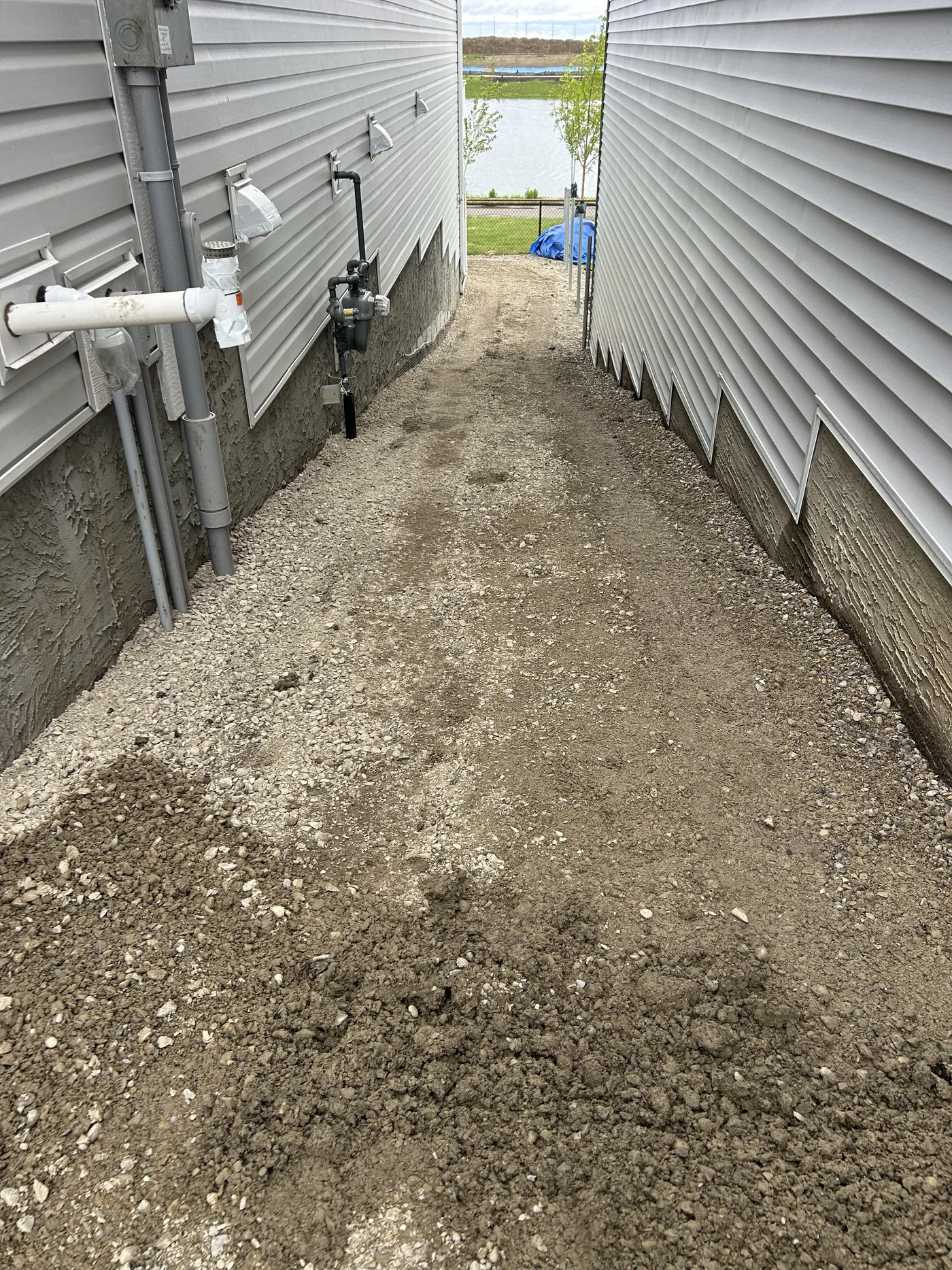 Side yard gravel surface after grading and crushed gravel placement in Calgary