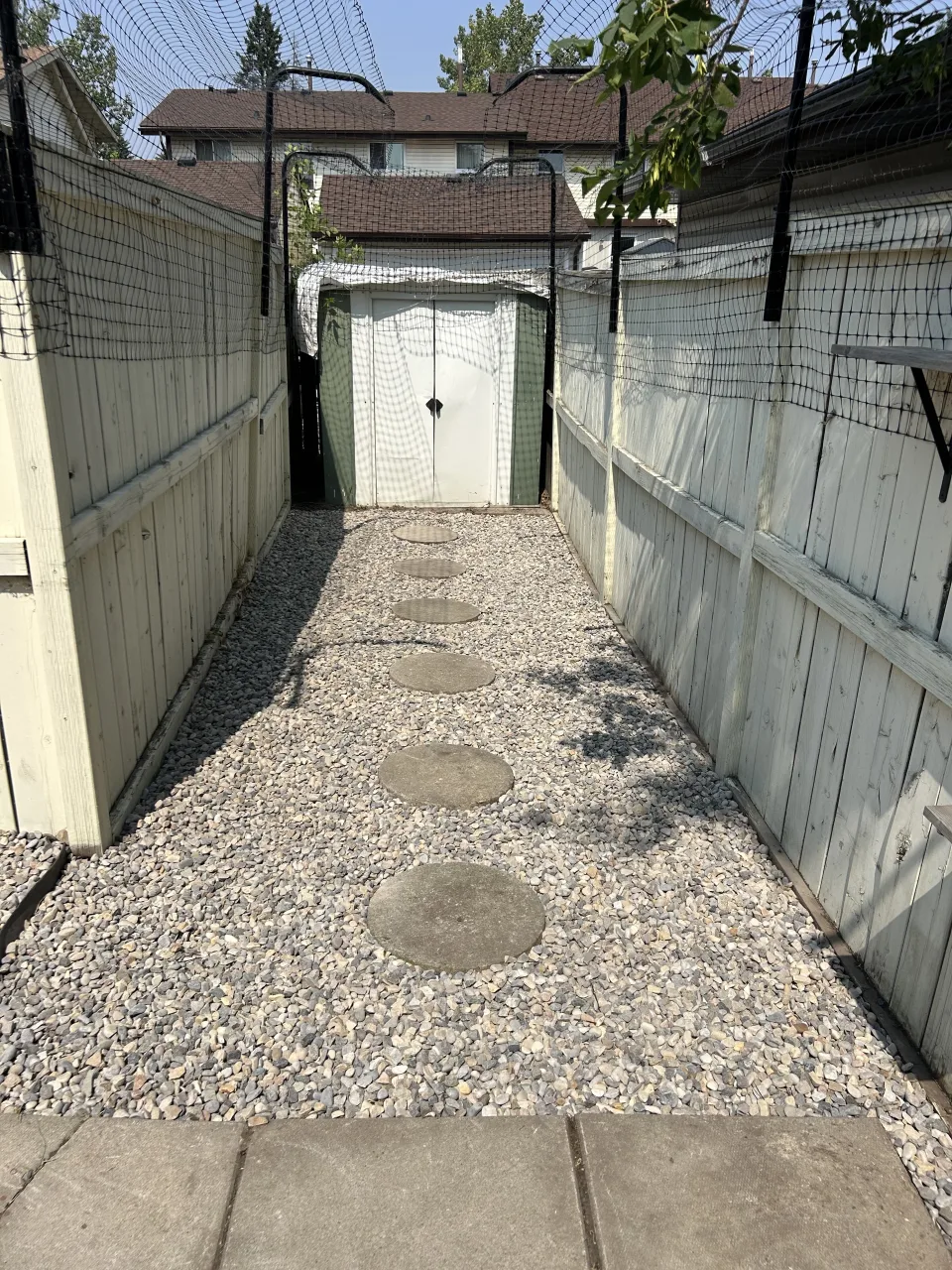 Calgary backyard after property sale cleanup with decorative rock and circular stepping stones