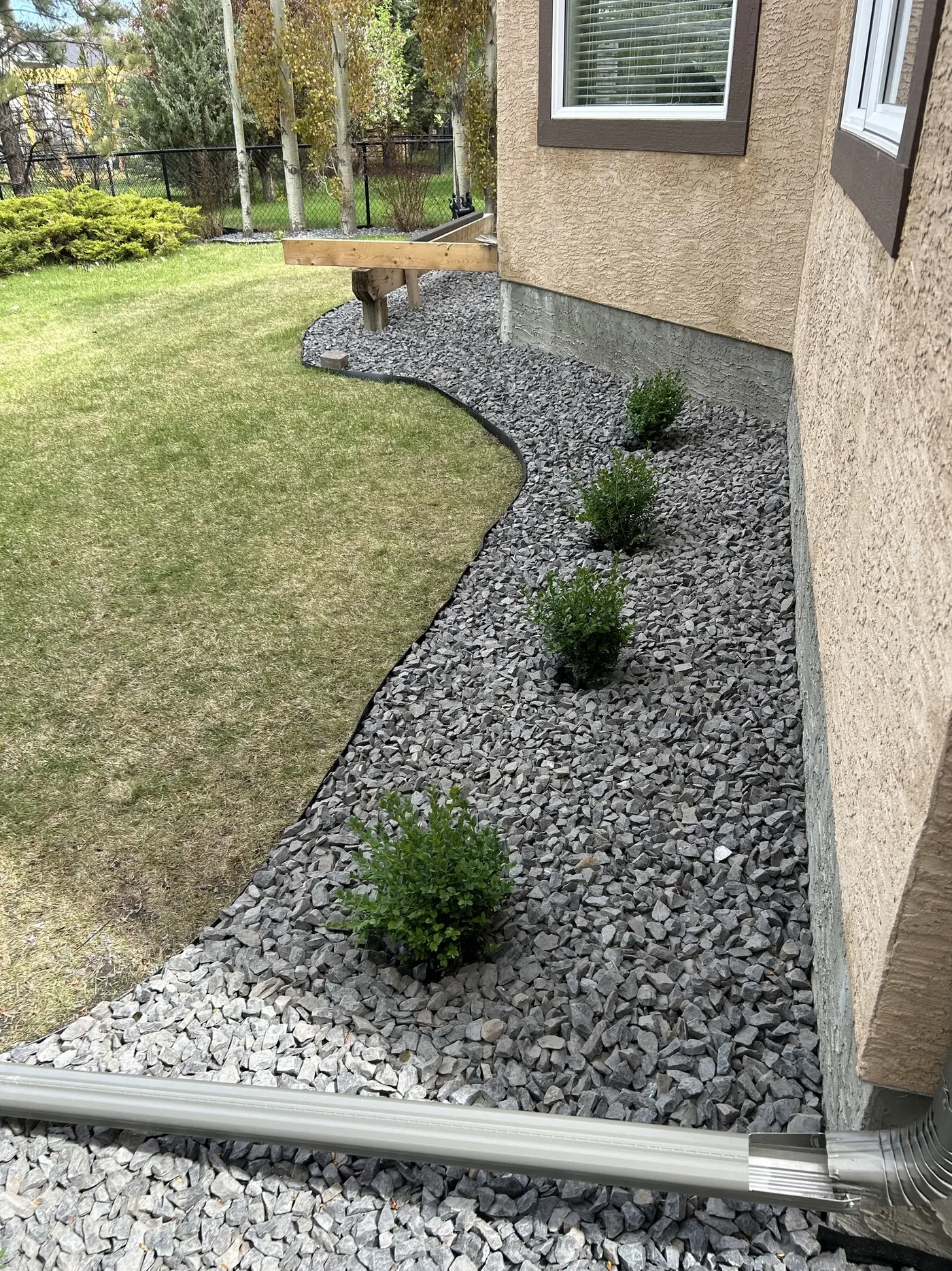 Finished backyard foundation edge with Rundle Rock in Calgary