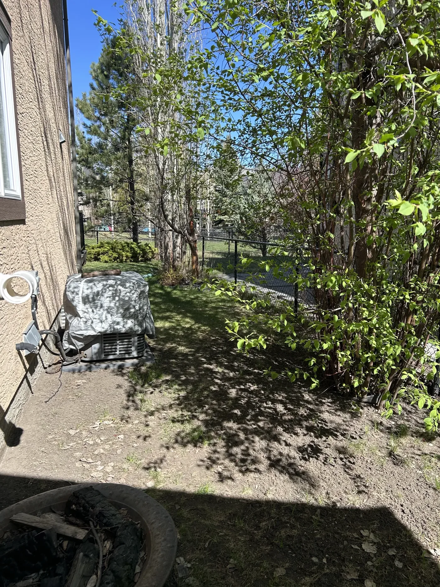 Side yard before grading with settled soil and poor drainage beside the foundation